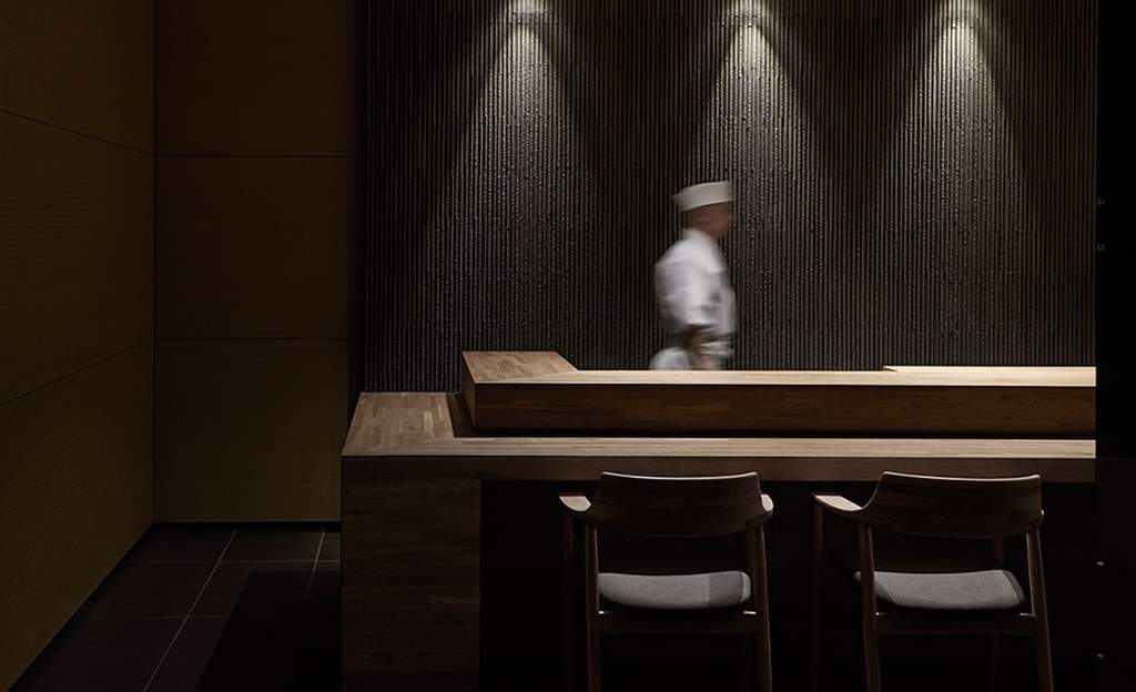 A chef walking past the main dining table at Minamishima - seafood sushi omakase restaurant in Richmond, Melbourne