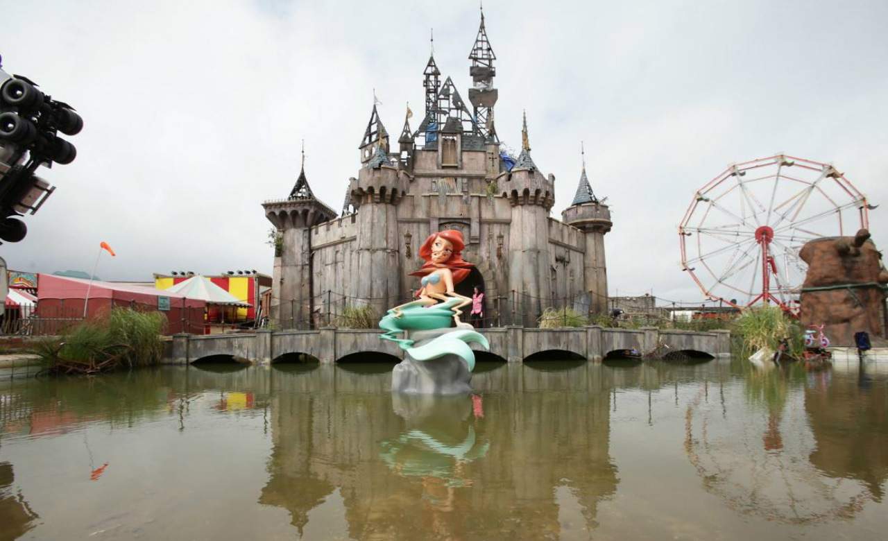 The entrance to Dismaland, a parody of Disneyland with a sign reading 'Welcome to Dismaland, the most disappointing place on Earth'