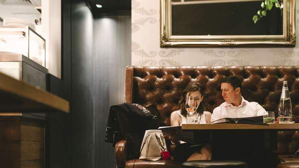 Two people relaxing while drinking wine at Cru Bar + Cellar in brisbane.