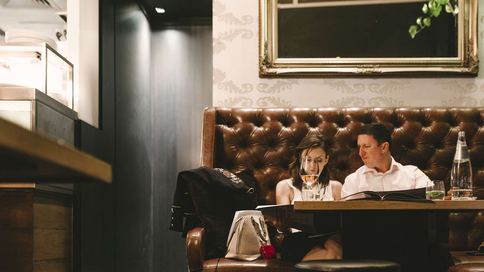 Two people relaxing while drinking wine at Cru Bar + Cellar in brisbane.