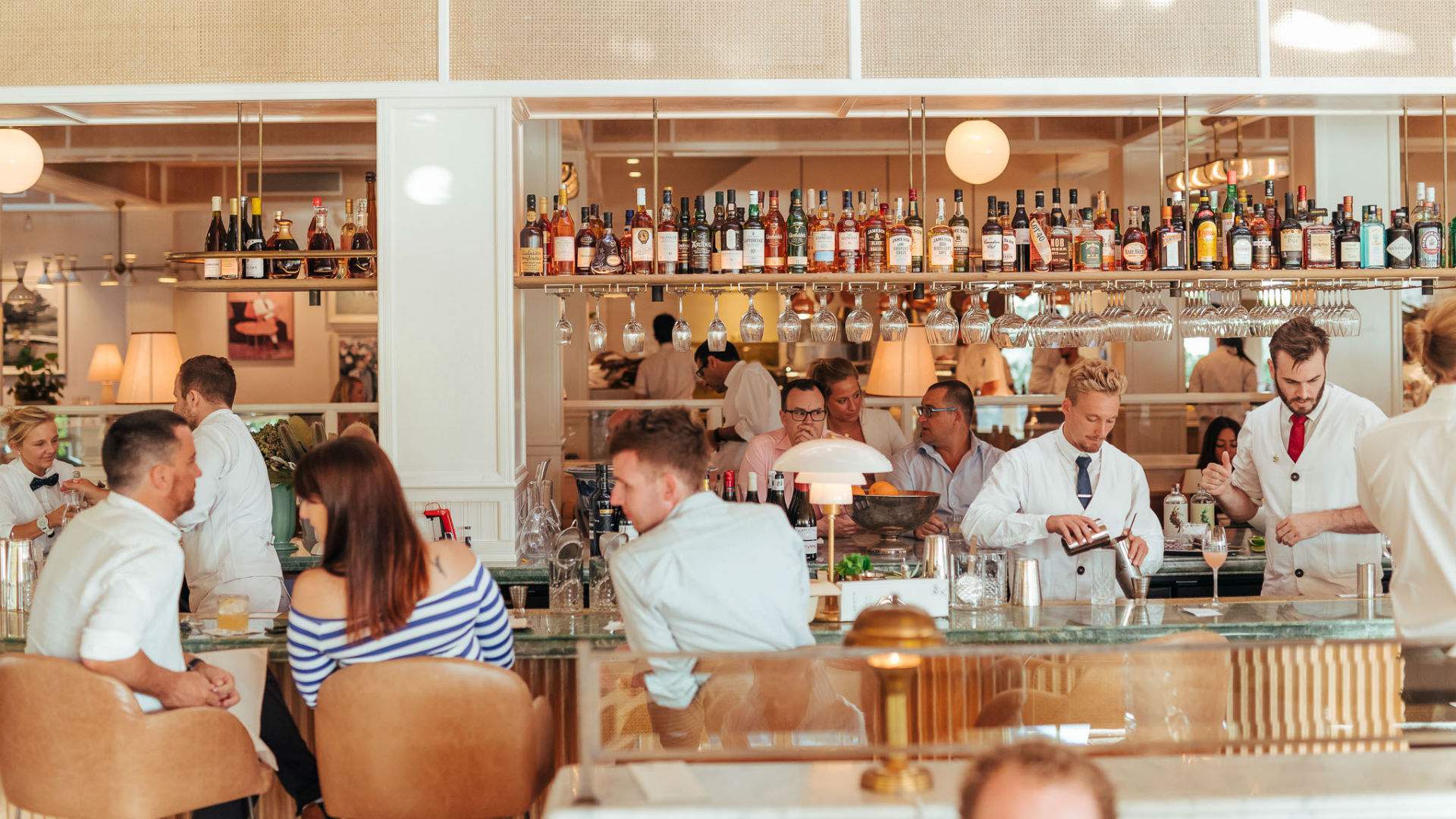 a busy bar with bartenders making cocktails at Bert's in Newport, Sydney