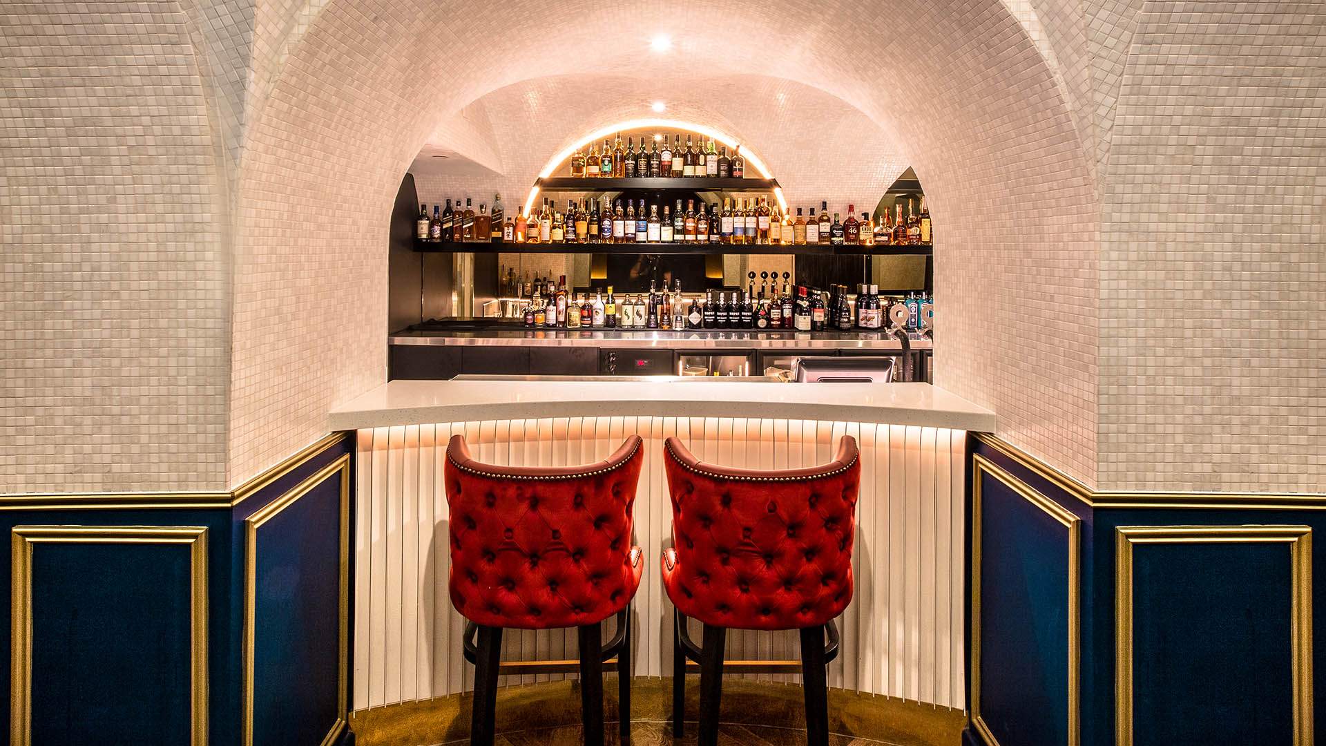 The interior design from inside the Boom Boom Room in Brisbane, two red chairs facing a small bar.