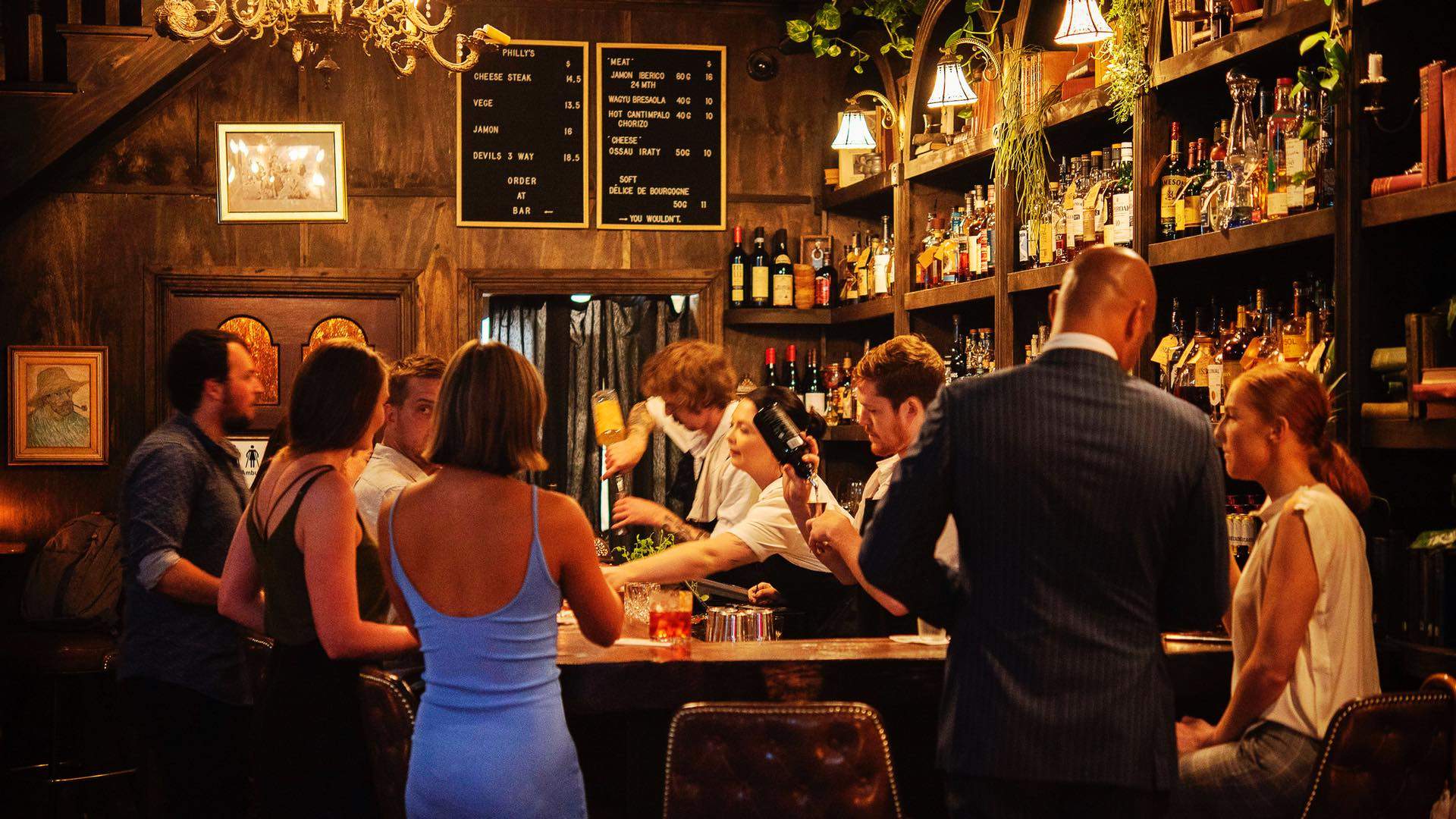 woman ordering a drink while bartenders work at old mate's place - one of the best bars in Sydney CBD