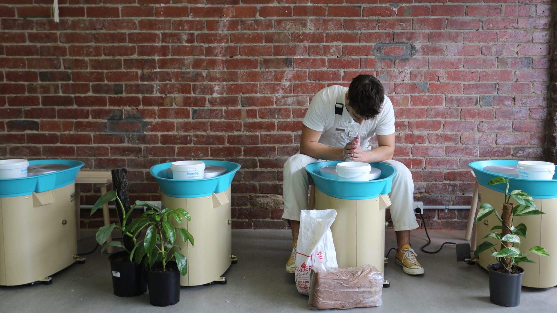 Person sitting at a pottery wheel.