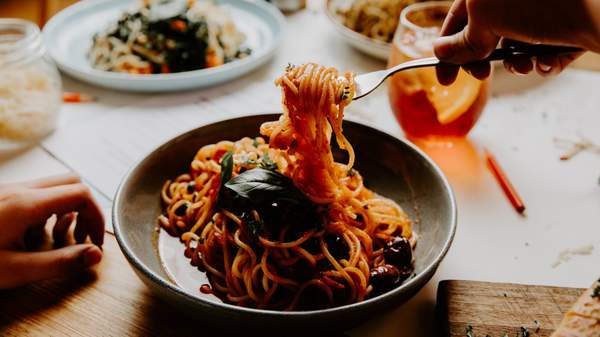 a person twirling spaghetti in a bowl at Good Times in Fitzroy