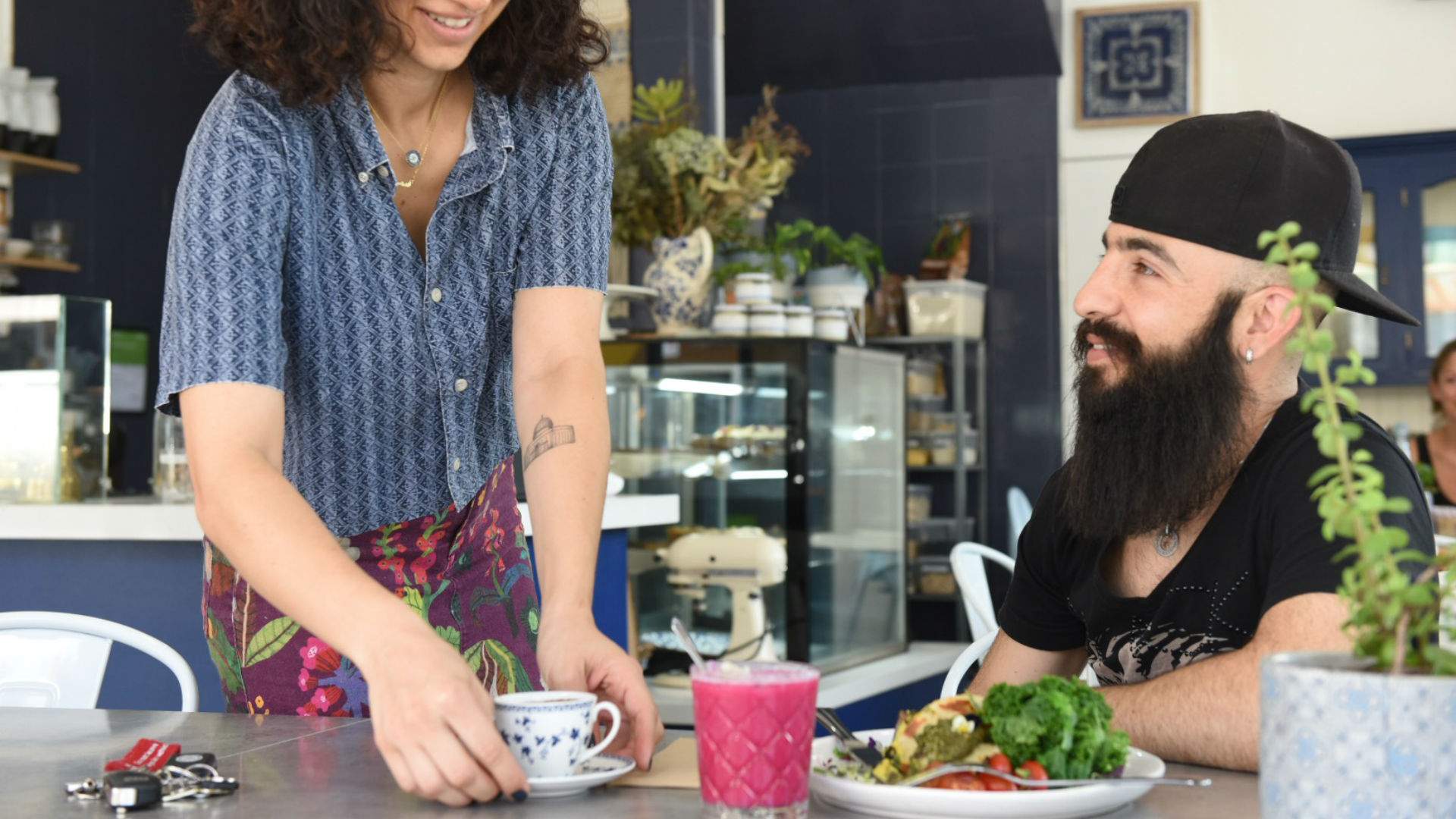server delivering teat to diner at Sydney's Khamsa Cafe - vegan cafe in sydney
