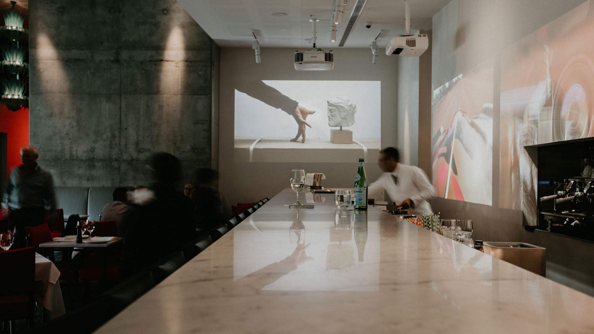 a bar with videos playing on the walls at Di Stasio Citta