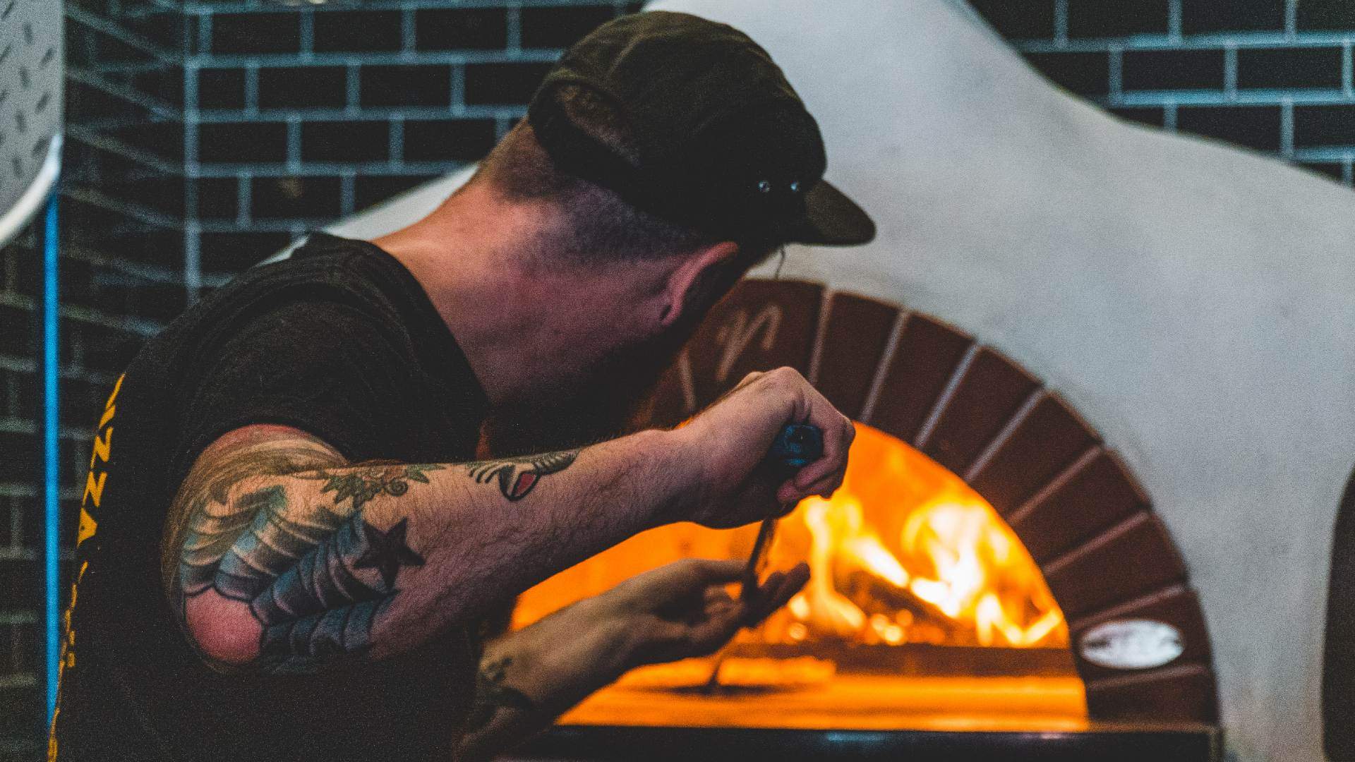 a chef cooking pizzas in the woodfire over - at Red Sparrow Pizza in Collingwood, melbourne