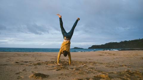 Man doing a handstand on a beach