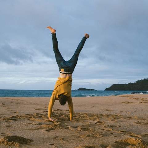 Man doing a handstand on a beach