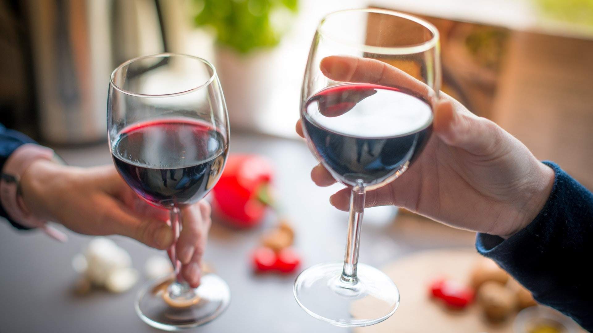 Two people toasting with red wine