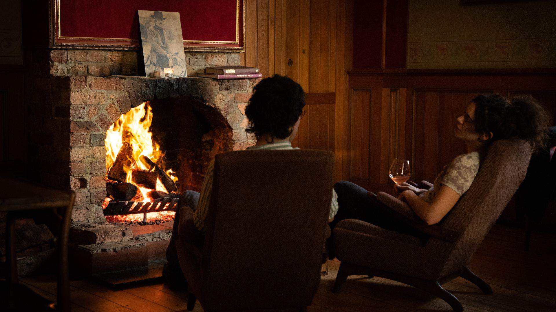 two people drinking by a fireplace in Neighbourhood Wine - one of the best wine bars in Melbourne