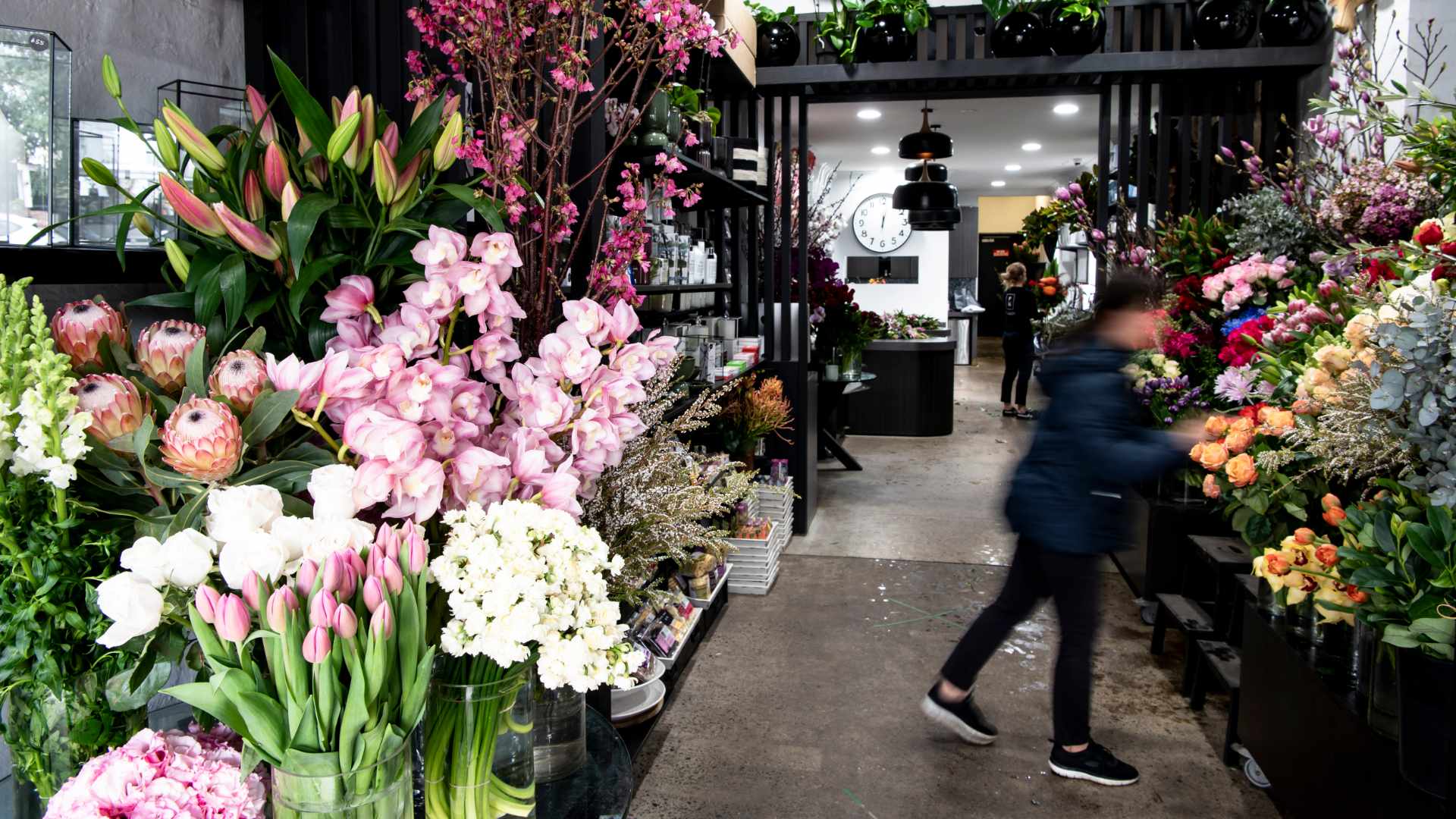 Florist moving around vases of flowers at Flowers on Norton Street