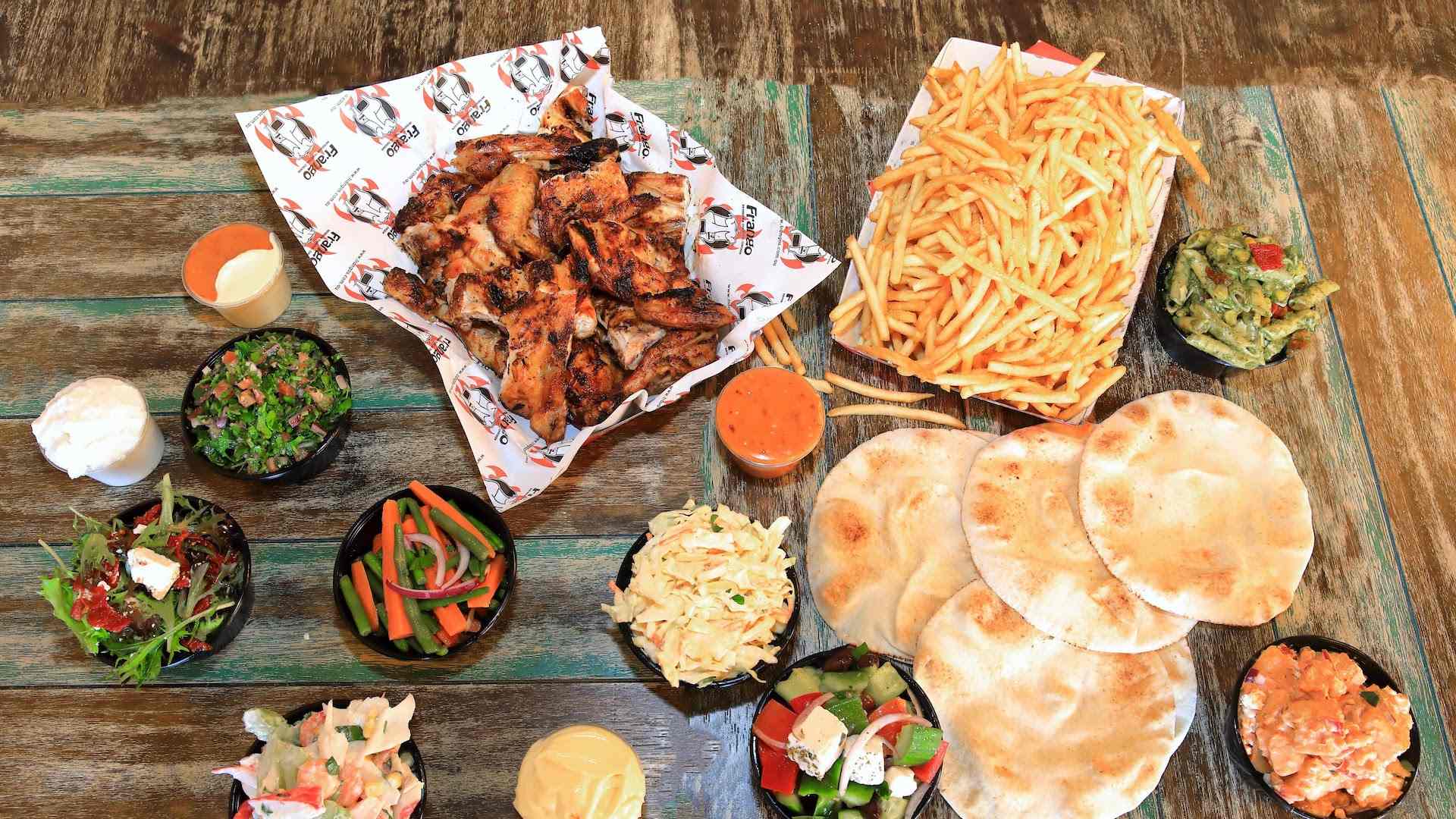 a huge spread of charcoal chciken, chips, flat bread and salads from Frangos Charcoal Chicken in Sydney