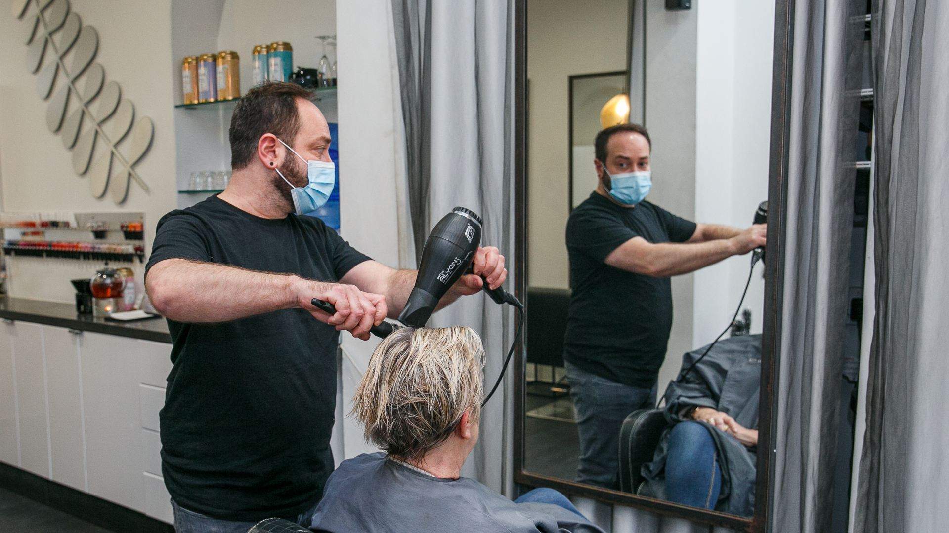 Hairdresser drying a customer's hair
