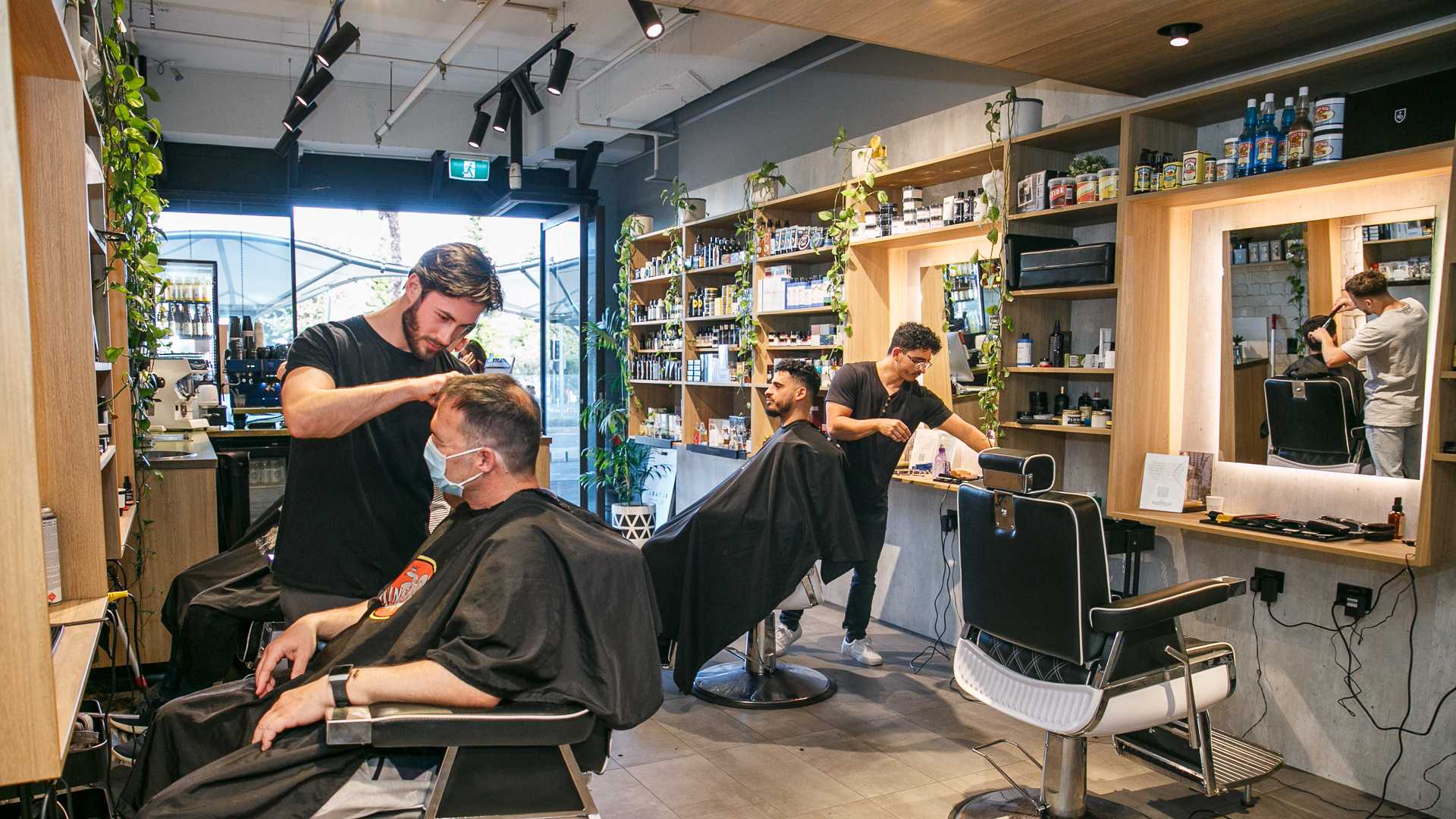 Barbers and customers in store at The Emporium Barber in Bondi