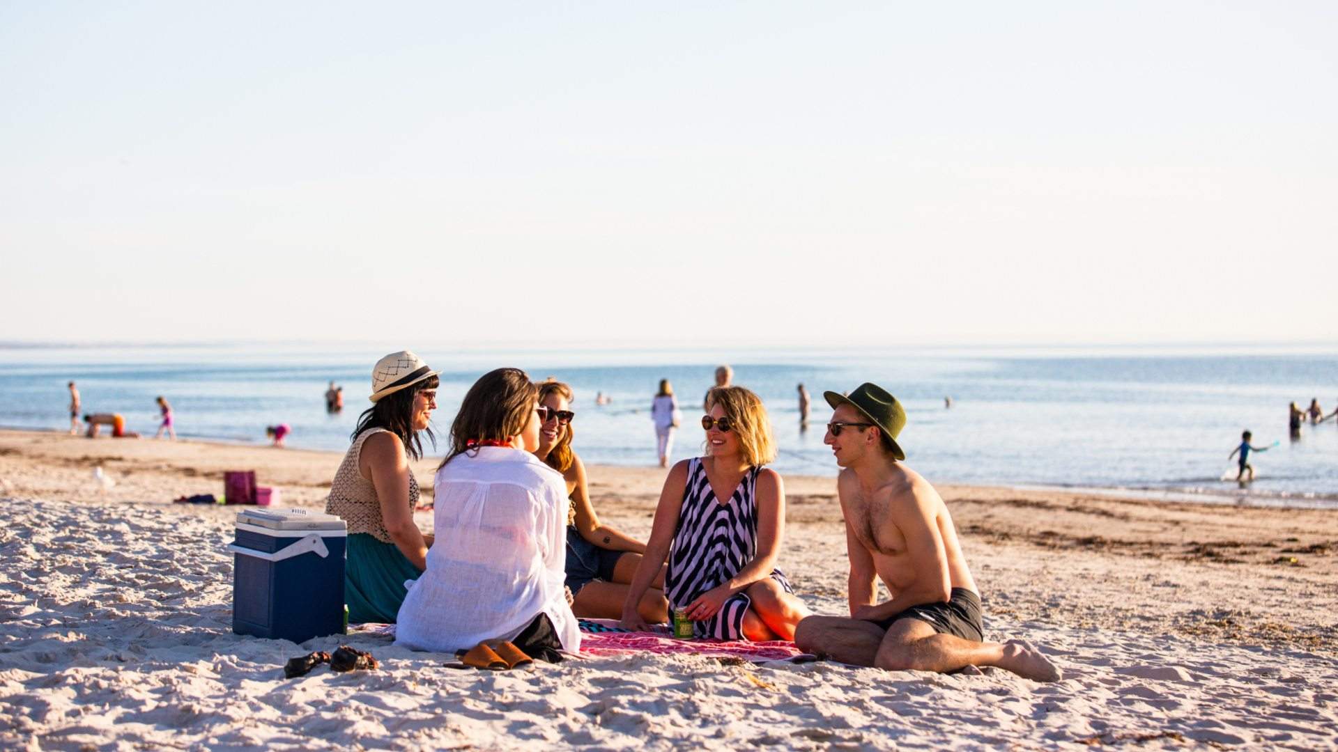 Group of friends sitting on the sand at Henley Beach