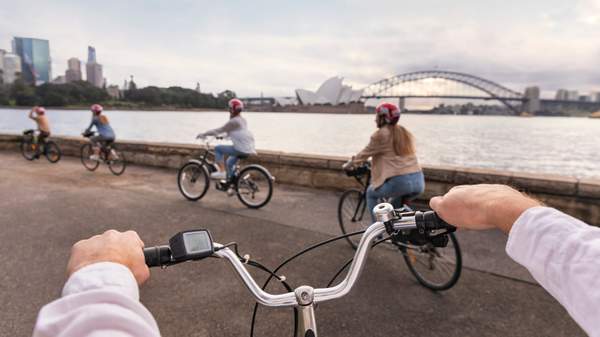 Family enjoying a ride through the Royal Botanic Garden Sydney on their hired bicycles from Bonza Bike Tours