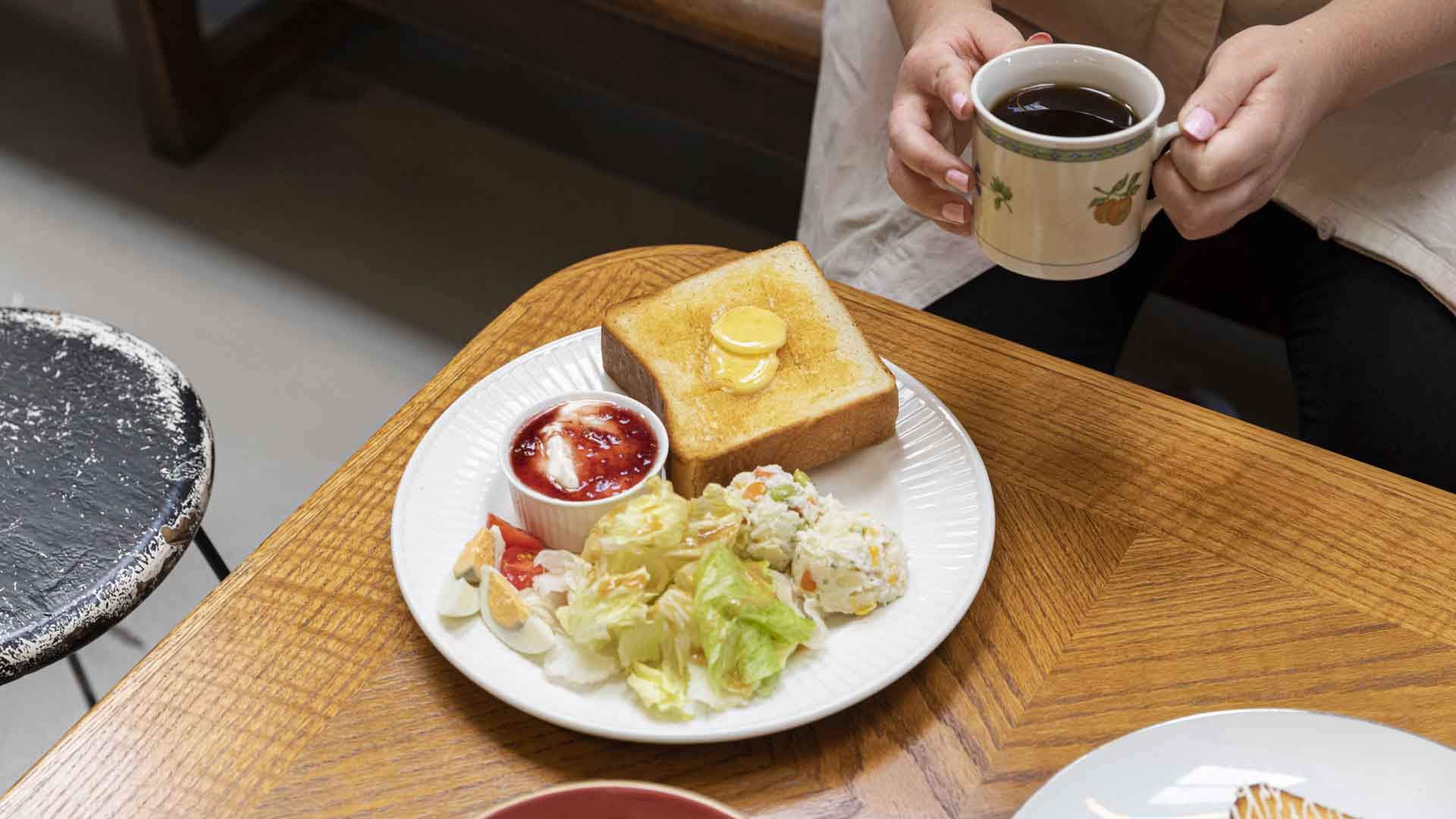 A plate with assorted foods and a mug of coffee served at Le Bajo Milkbar.