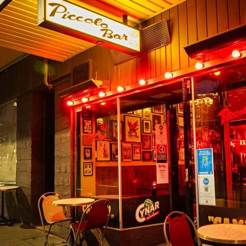 two small empty tables with chairs lit up by red lights at Piccolo Bar - one of the best bars in Sydney - bar king's cross