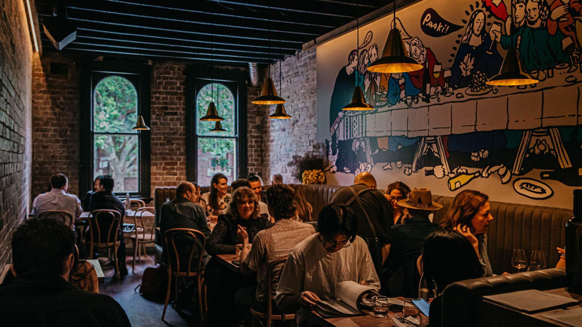 a large group of people drinking and eating in the dining room at Paski Vineria Popolare - one of the best bars in Sydney