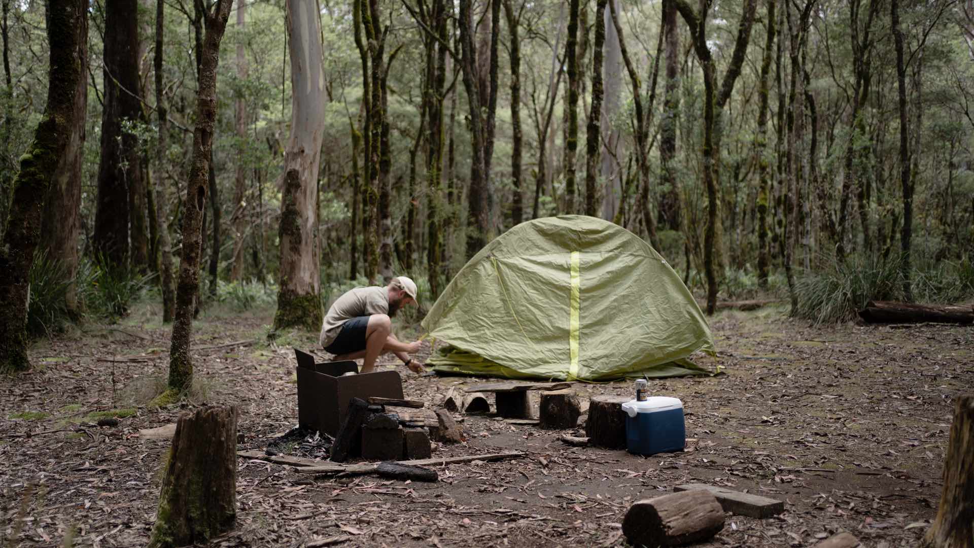 Man setting up tent at campsite