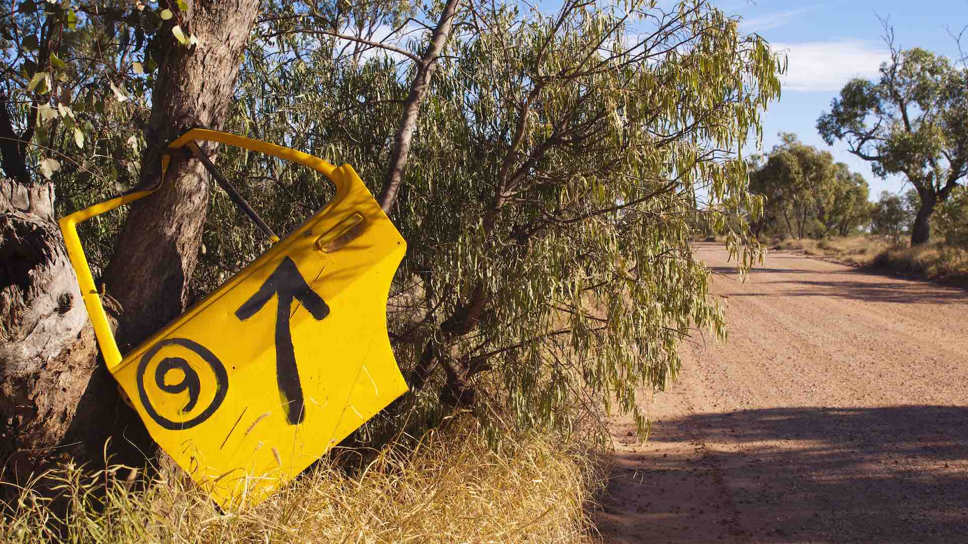 Old yellow car door used as a street sign in outback Australia