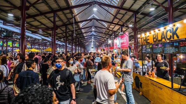 Crowd enjoying the food stalls in the shed at Queen Vic Market