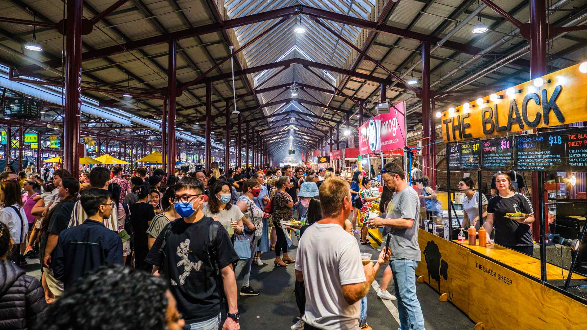 Crowd enjoying the food stalls in the shed at Queen Vic Market