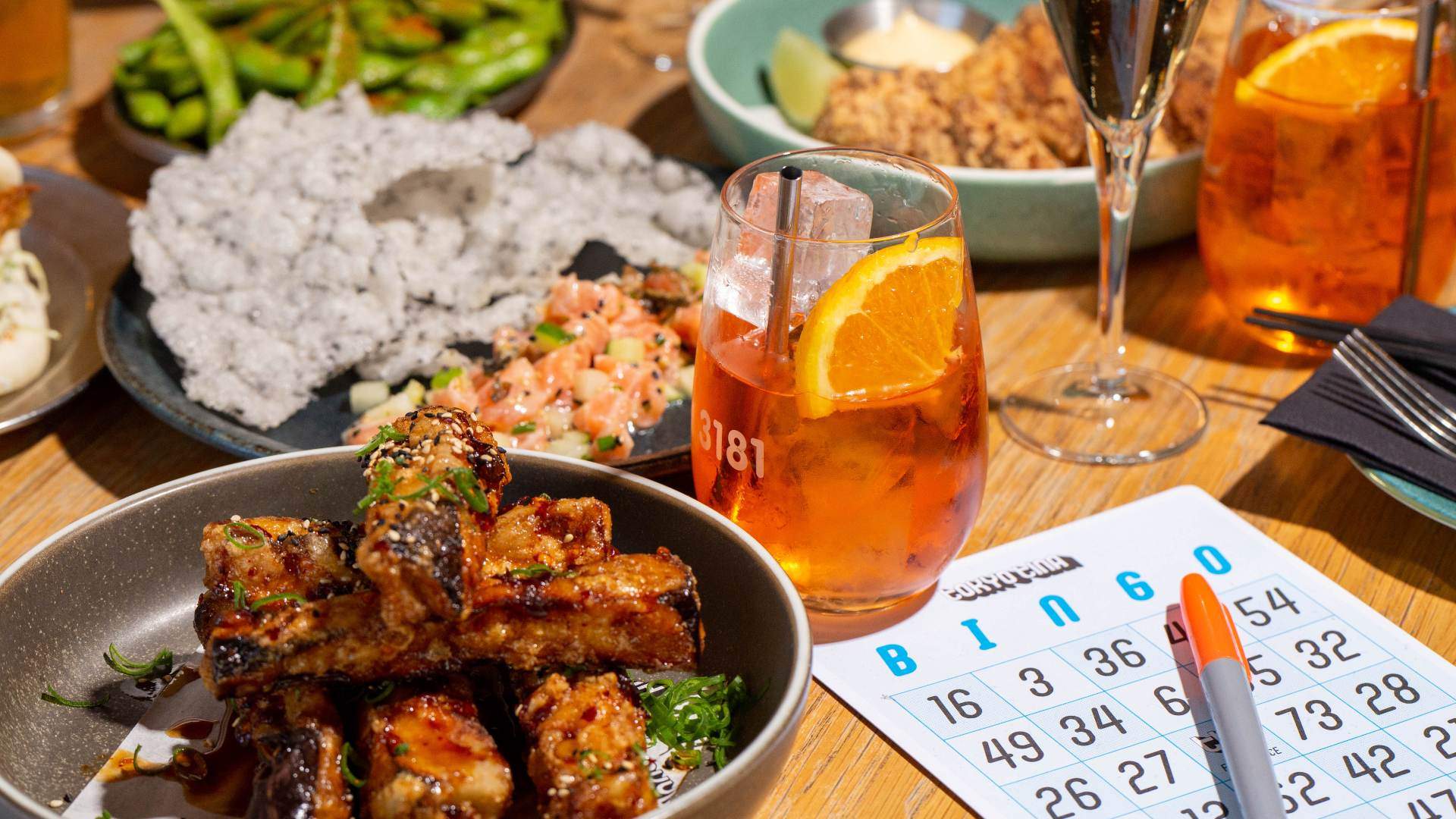 Table of food and cocktails with a bingo card