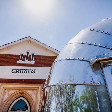 Upwards shot of Trinity's facade and the Airstream beside it