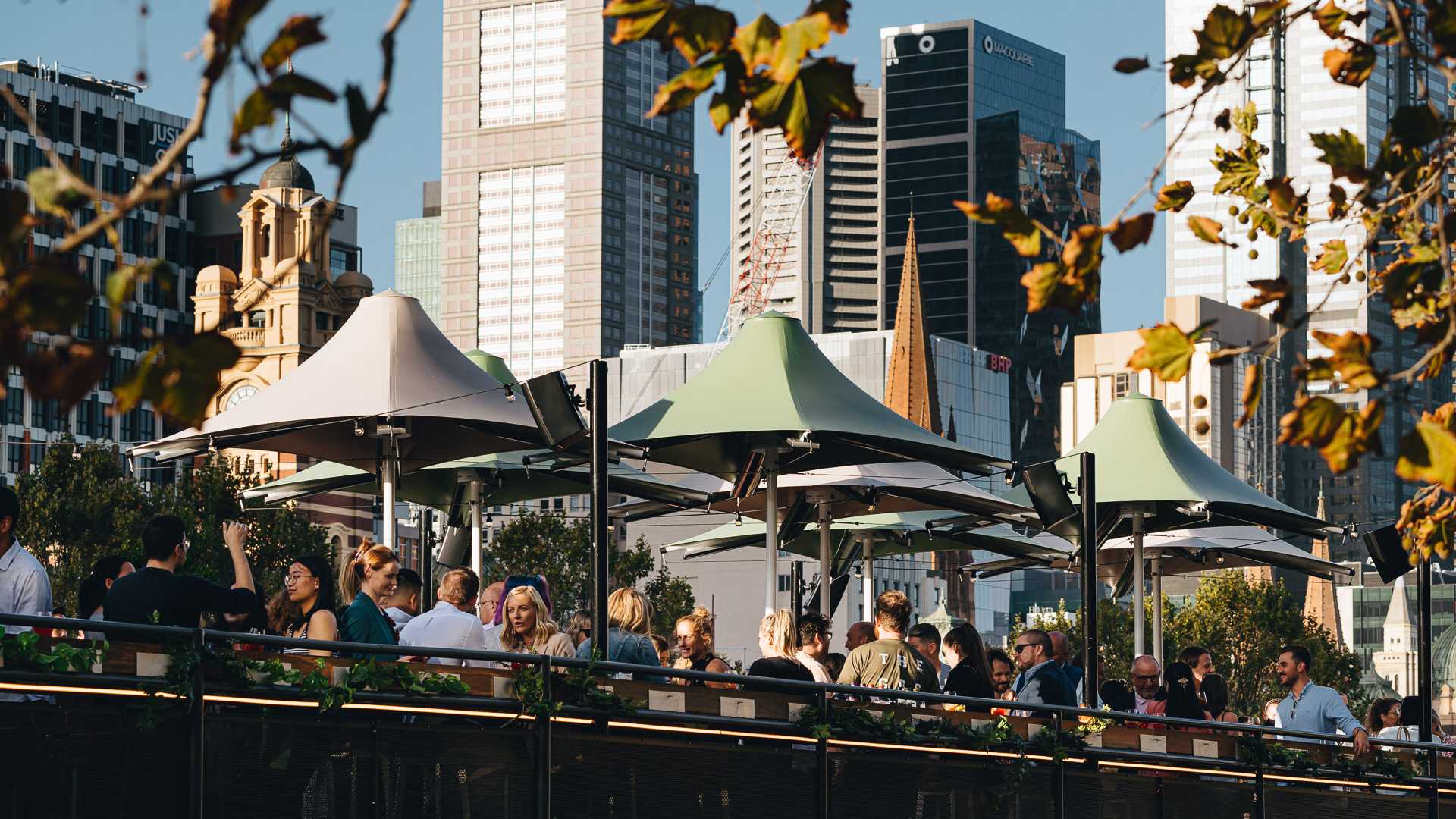 People sitting under umbrellas on the deck of Yarra Botanica