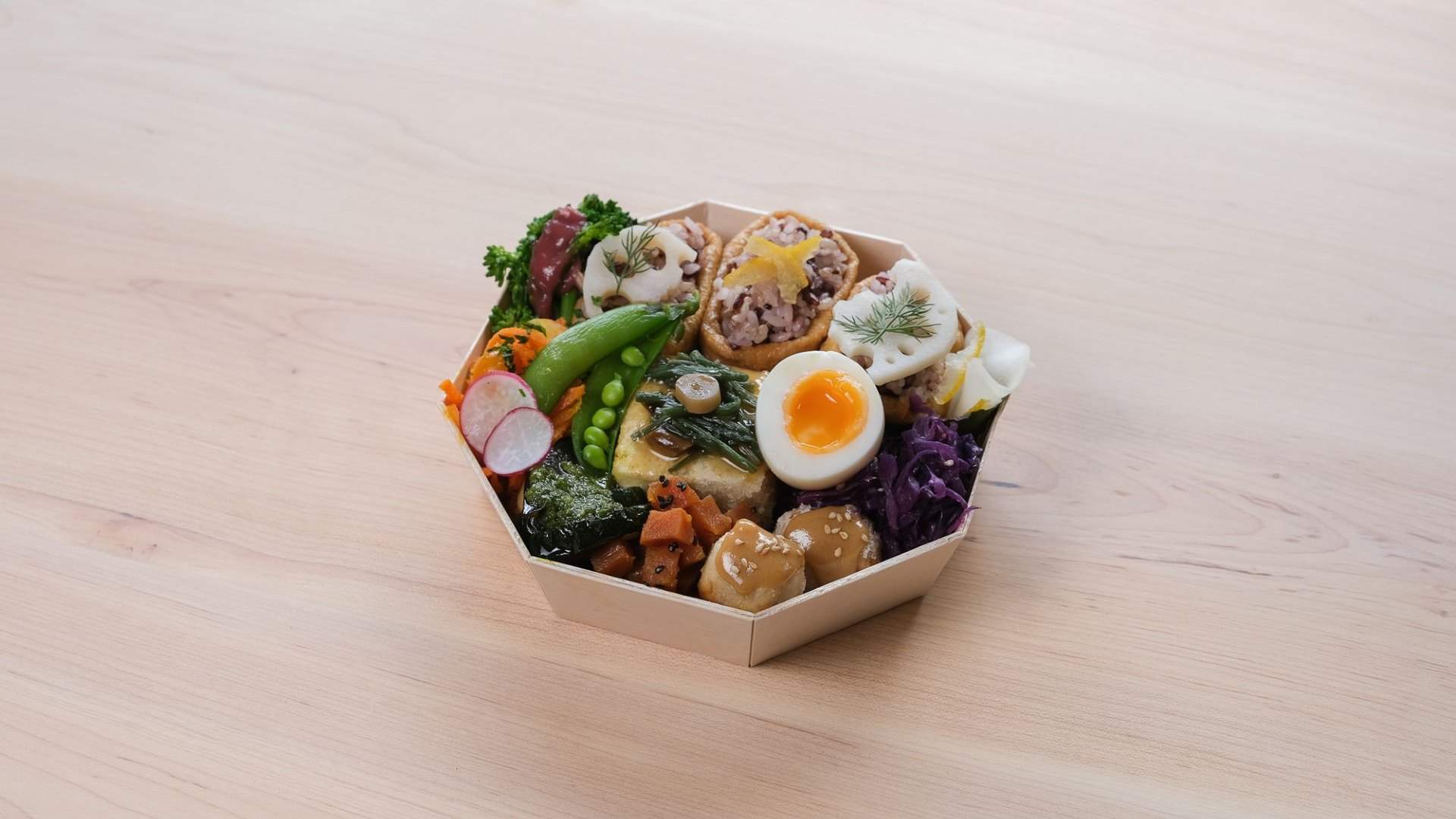 A close up of a bowl packed with assorted foods sold at Hareruya Pantry.