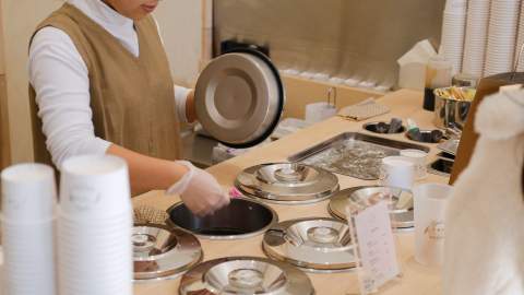 Worker scooping gelato out at Hareruya Pantry.