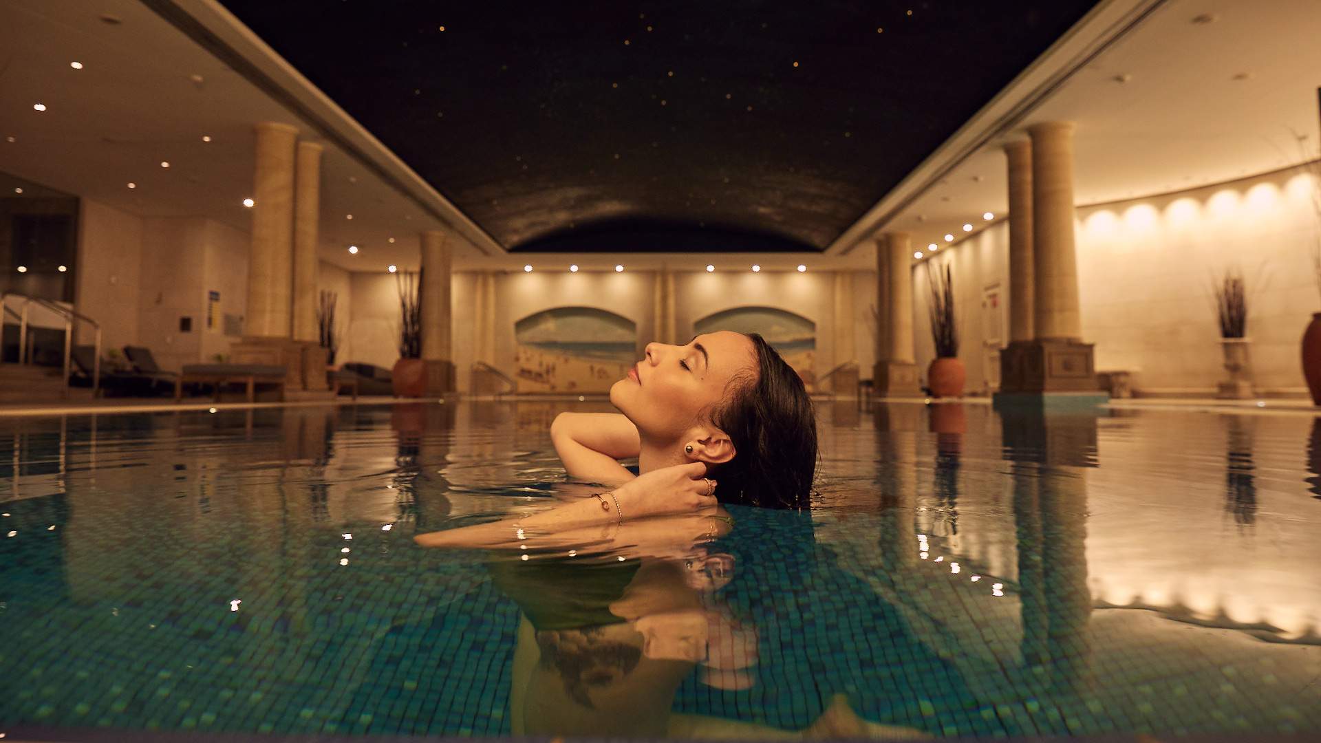 A woman swimming in the pool at The Langham - home to one of the best spas in Melbourne