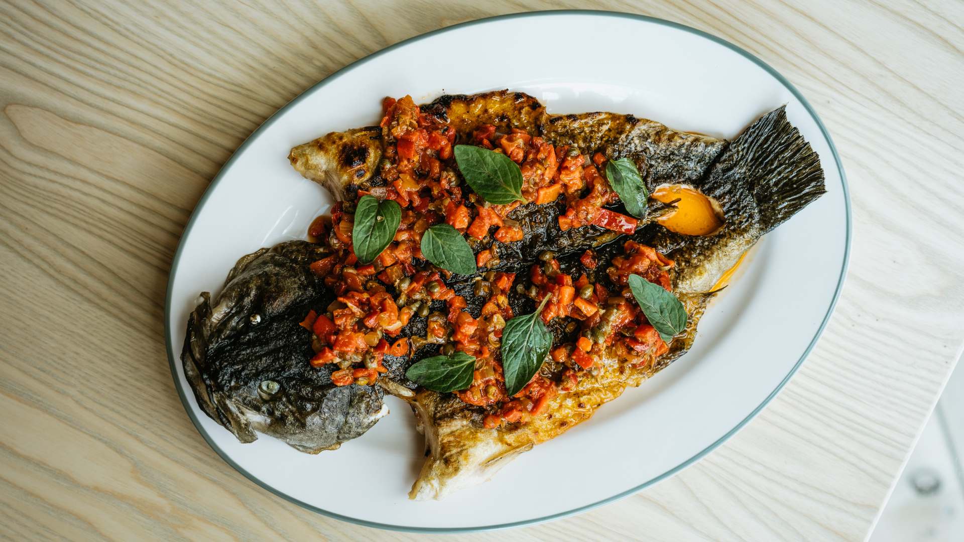 a whole baked fish on a plate from Stokehouse Pasta & Bar