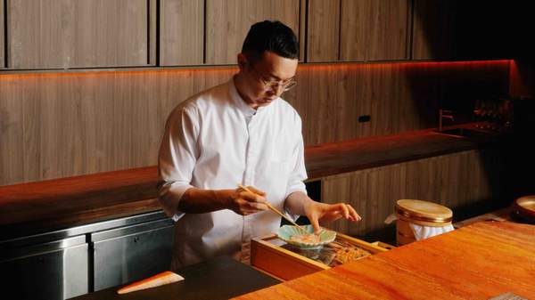 Chef Alex Yu carfelly plating dishes at Yugen Dining in Melbourne
