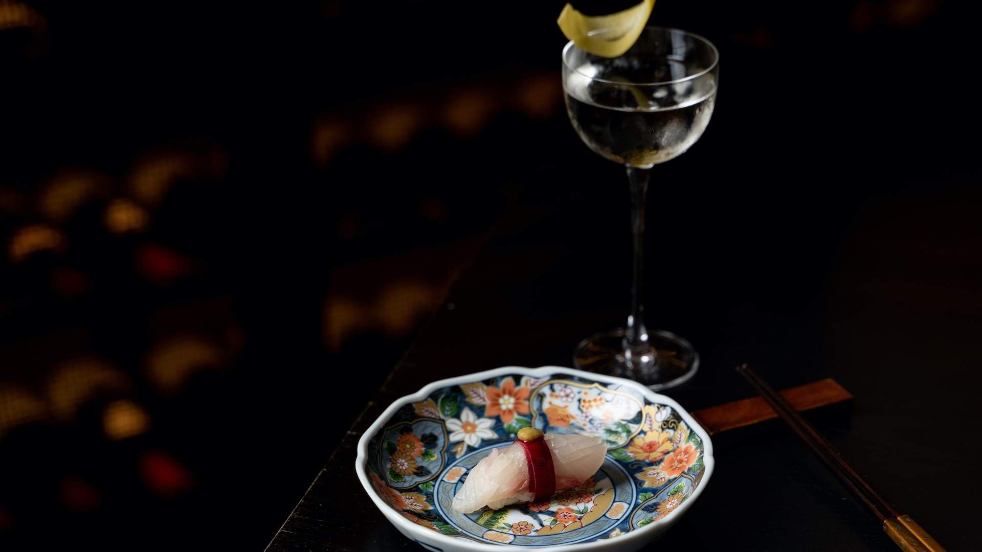 A glass of wine next to a plate which presents a small portion of a Japanese dish served at Kisume, Melbourne.