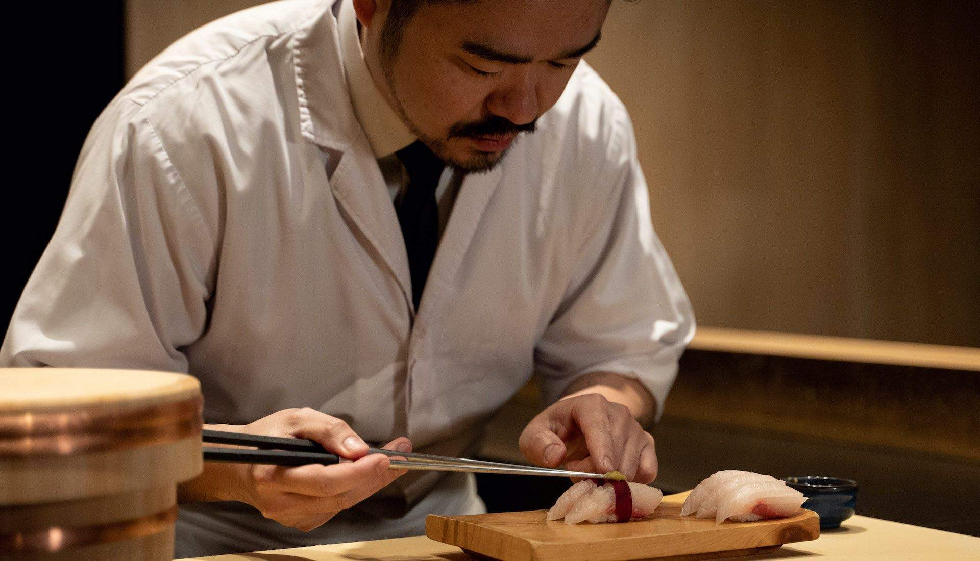 A chef using a knife to cut fish.