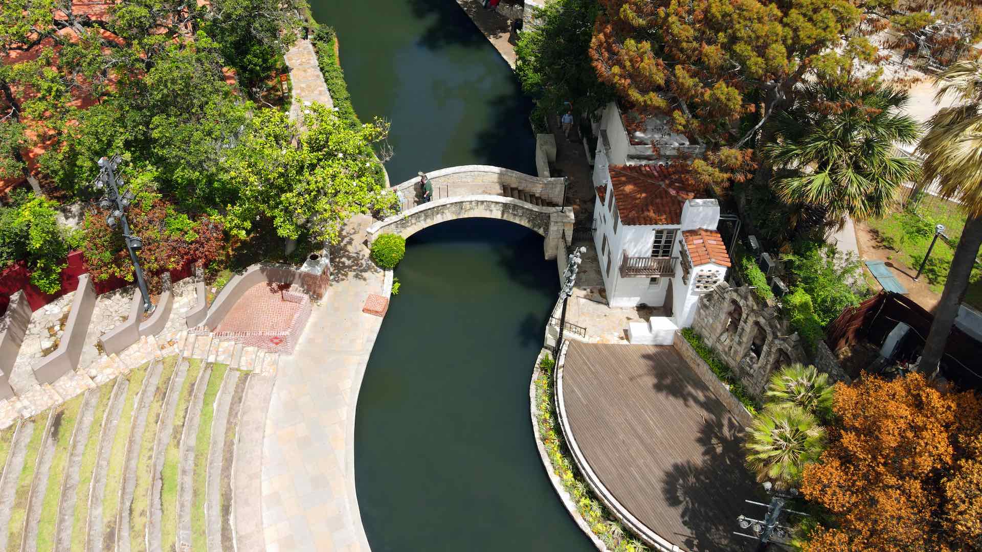 Aerial view of bridge, amphitheater, and waterway of San Antonio Riverwalk