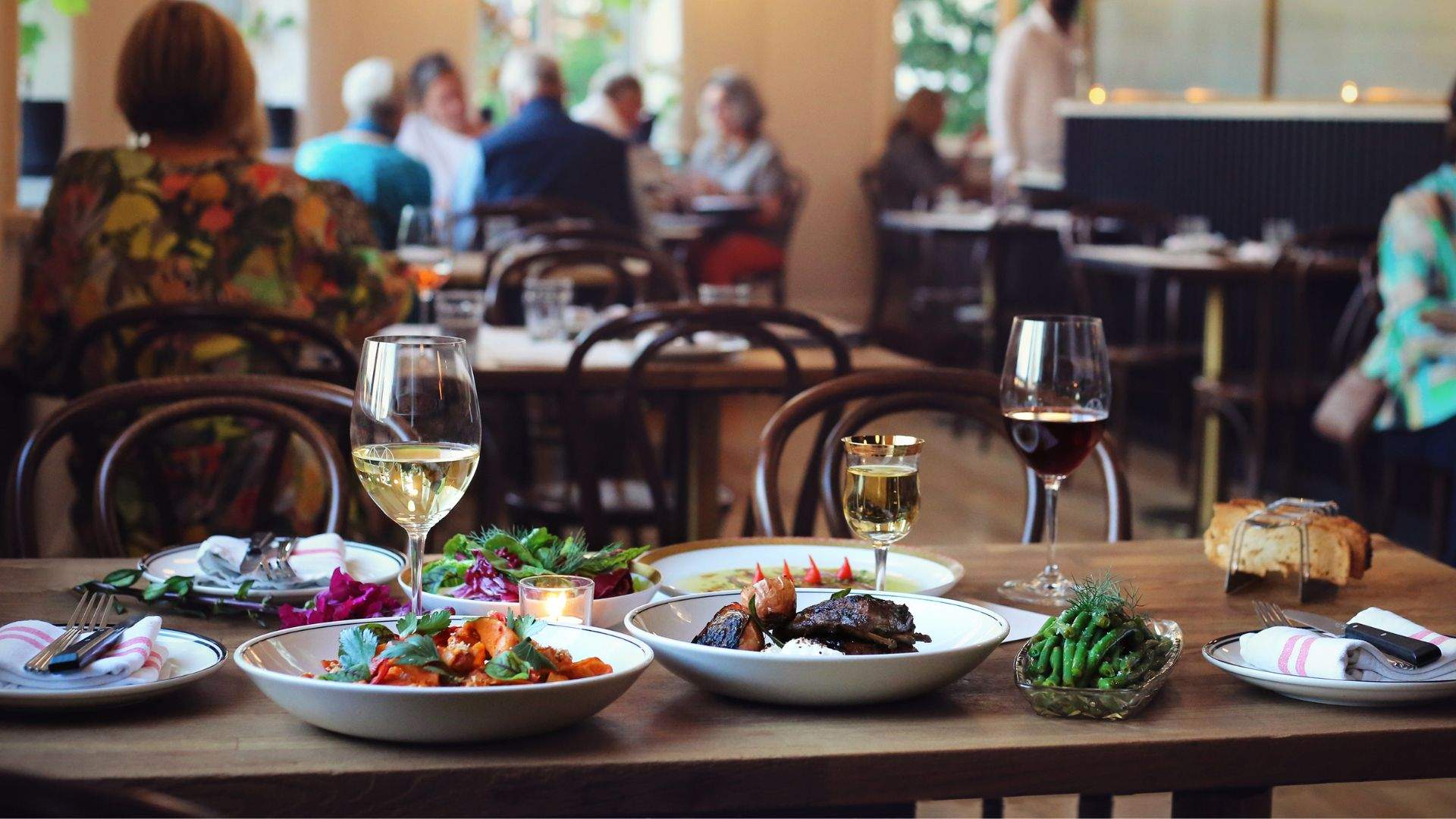 A selection of dishes and glasses of white wine at Maeve Wine Bar in Brisbane.
