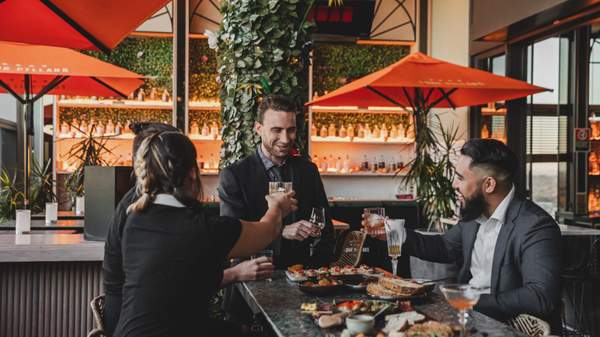 Photo of four friends having drinks and appetisers at Nick & Nora's bar.