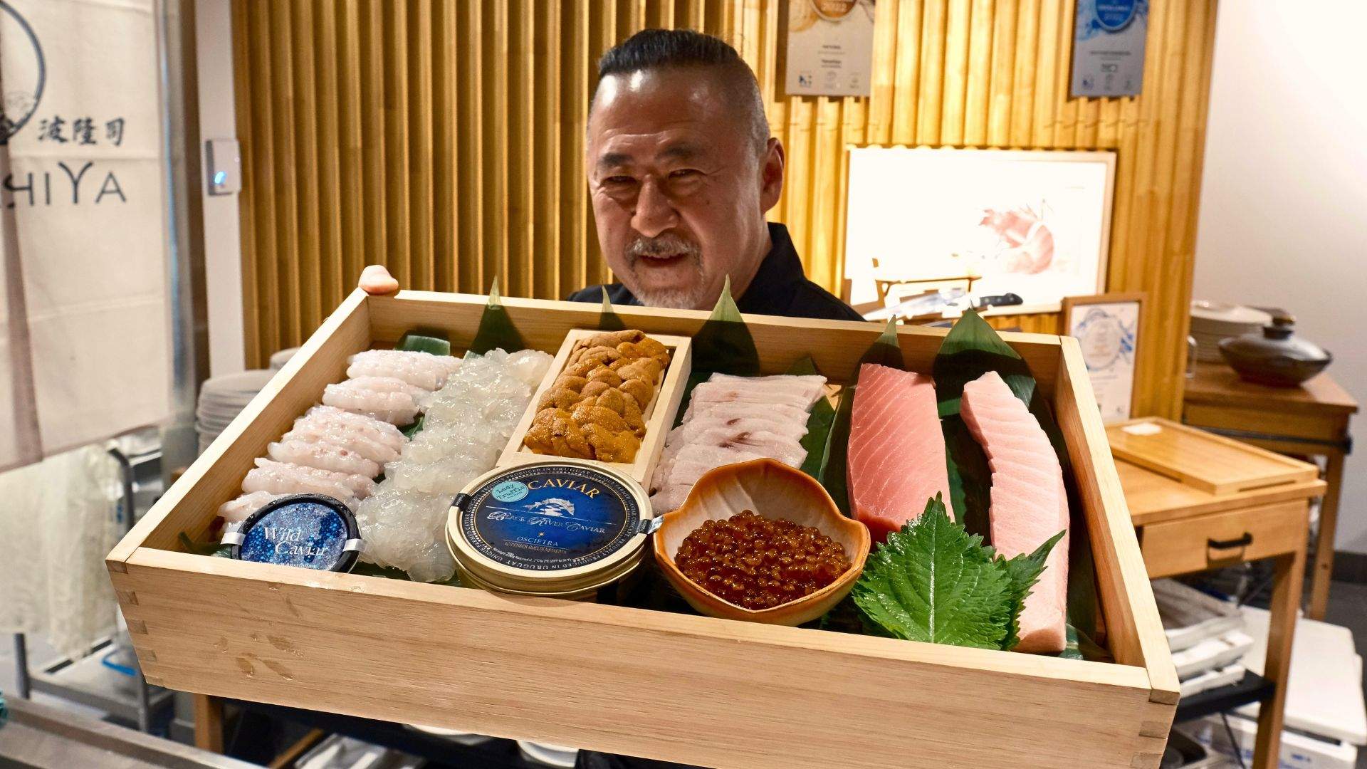 Chef Takashi Nami showing a platter of Japanese eats at Takashiya - one of the best Japanese restaurants in Brisbane.