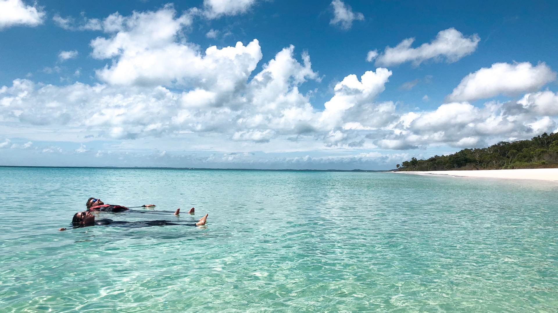 Photo of two people floating in the water at K'gari.