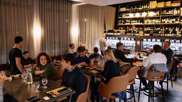 A shot of the wine bar full of customers dining in. 