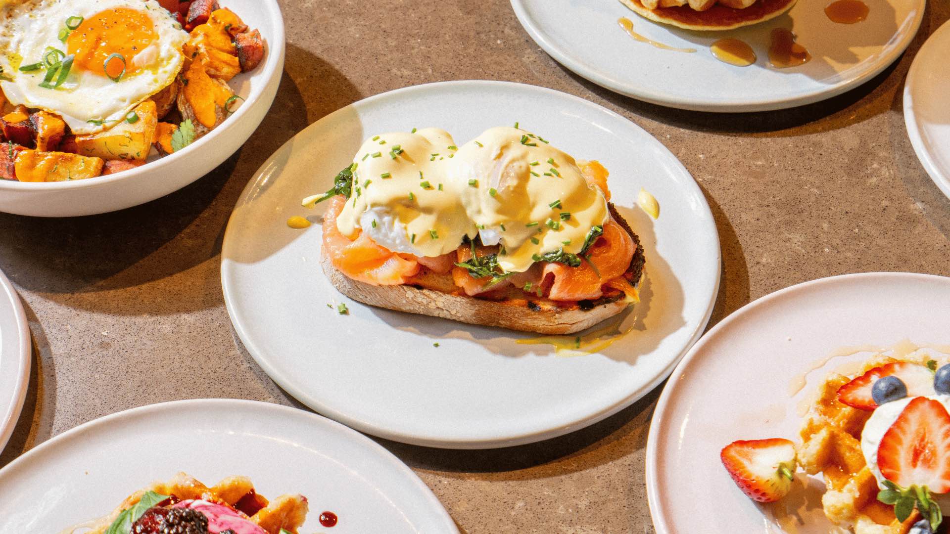 An eggs benedict and other brunch dishes.