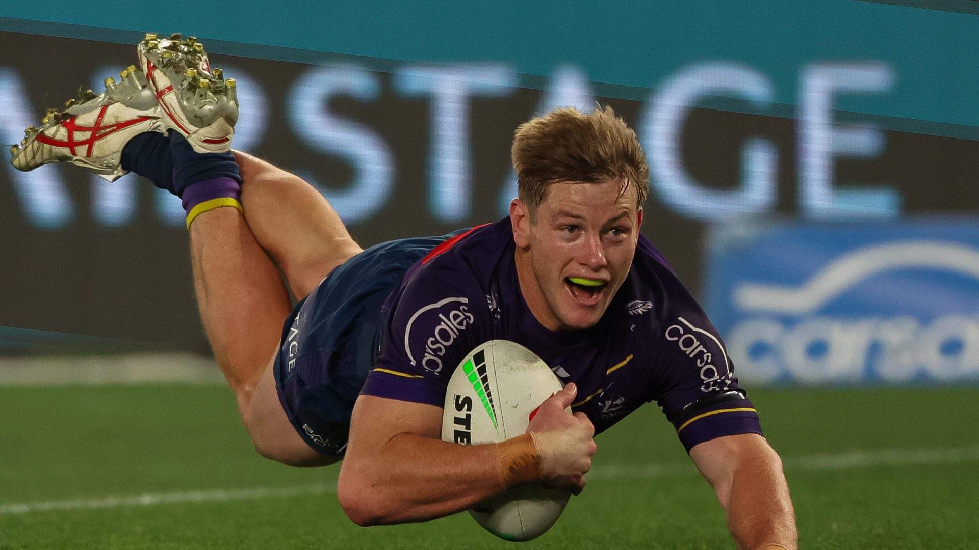 Photo of NRL player diving with the ball.