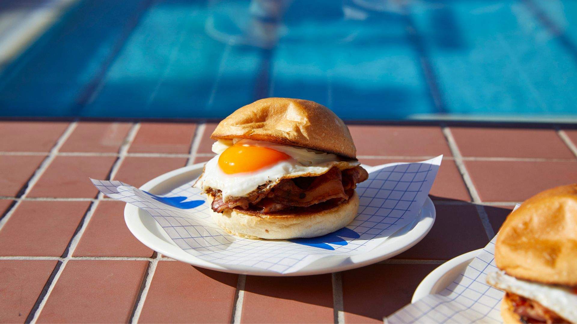 Bacon and egg roll sitting poolside (from Oh Boy Café).