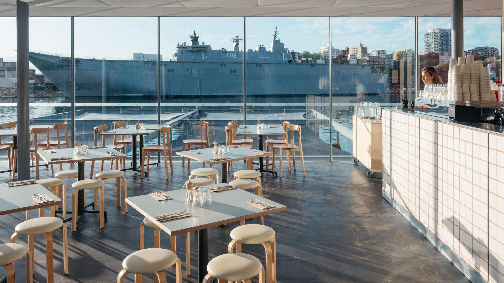 Indoor seating of Oh Boy Café, featuring floor-to-ceiling windows capturing the panoramic waterfront views.