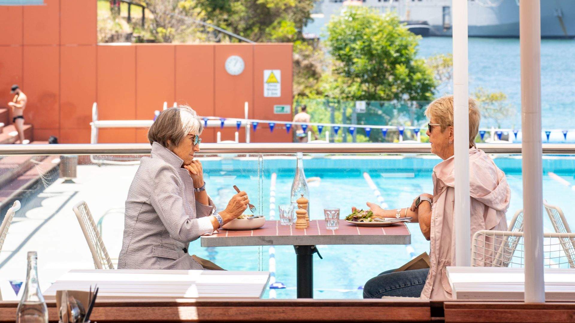 Two older women dining on the outdoor terrace of Oh Boy Café.